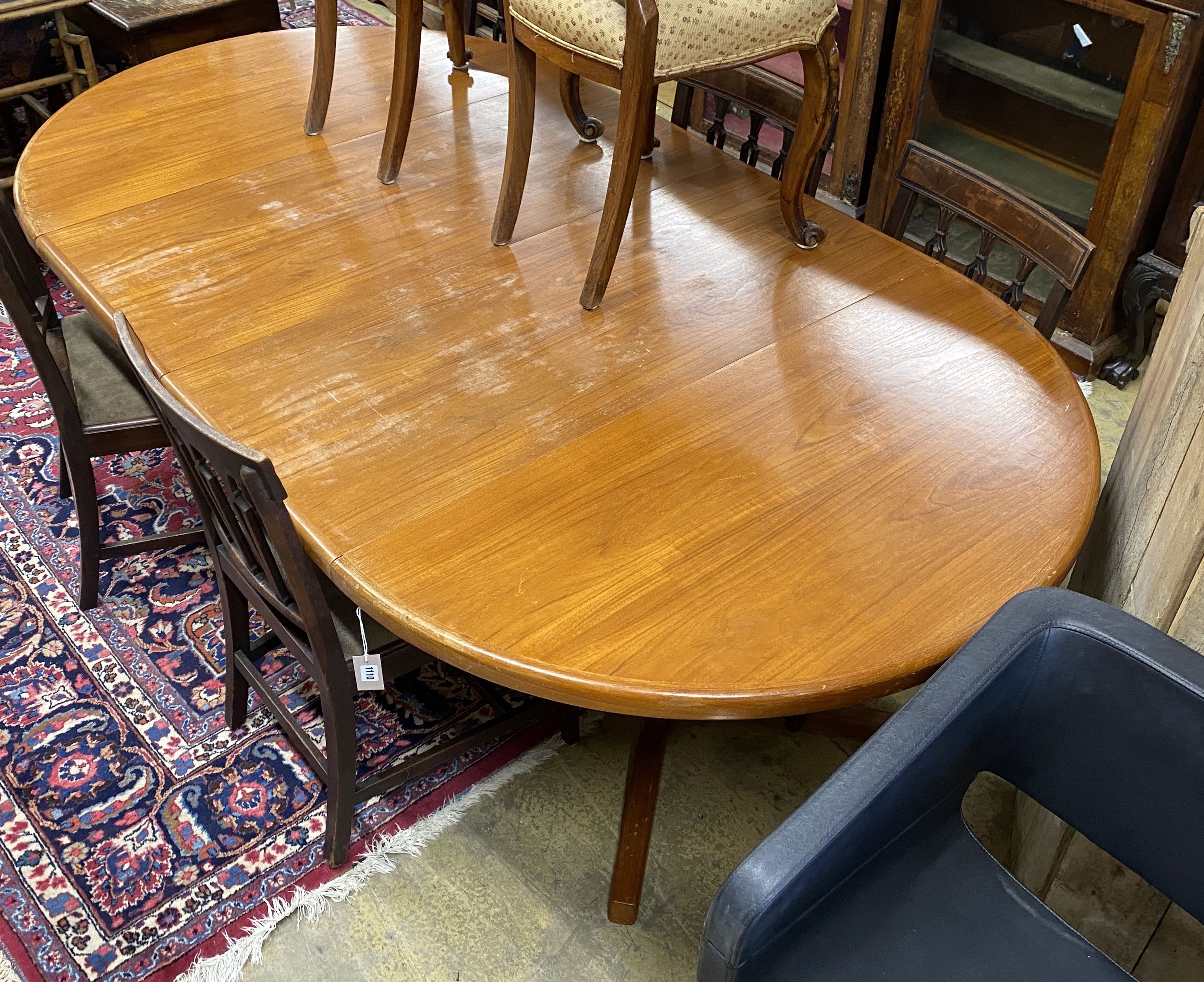 A mid century Danish teak circular extending dining table, two spare leaves, 220cm extended, width 120cm, height 72cm